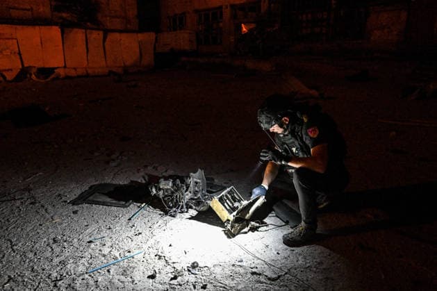 A volunteer of the ARTAK Charity Foundation uses an electric torch to examine Russian drone debris at a shopping complex after a Russian attack in Zaporizhzhia, Ukraine, July 25, 2026. In the early hours of Saturday, July 25, Russian troops struck the southeastern Ukrainian city with drones, igniting a fire that spread through shops and trading pavilions over an area of about 900 square metres. A 63-year-old man was injured in the drone strike. (Photo by Dmytro Smolienko Ukrinform) Russian army attacks Zaporizhzhia with drones  Copyright: xDmytroxSmolienkox