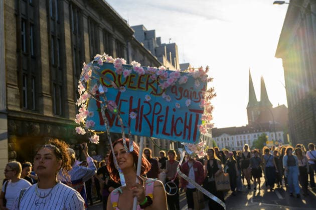 July 24, 2026, Berlin, Berlin, Germany: A person holds a placcard against the mandatory military conscription (Wehrpflicht) decorated with flowers at Dyke* March 2026, on July 24 2026, in Berlin, Germany. Thousands of demonstrators marched in the streets of Berlin s City Center and Kreuzberg districts for the annual Dyke* March just a day before the annual CSD parade and Internationalist Queer Pride Berlin Germany - ZUMAk201 20260724_zip_k201_007 Copyright: xNikosxKanistrasx