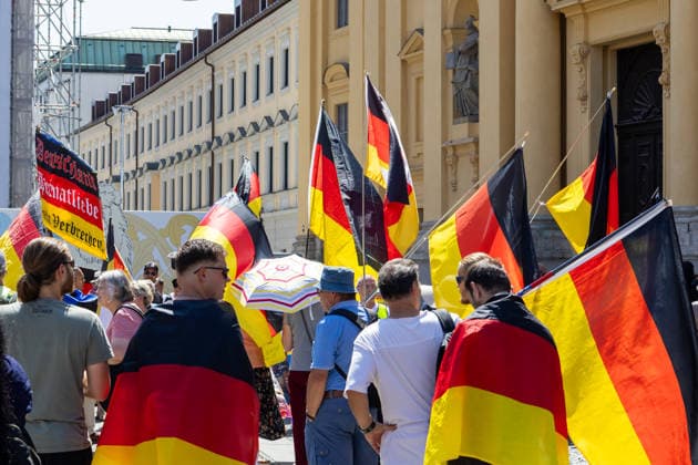 Munich, Bavaria, Germany July 25, 2026: Protesters demonstrate in downtown Munich against Chancellor Friedrich Merz (CDU) and the federal government™s policies. The rally is directed, among other things, against the government™s economic and social policies. Protesters carrying German flags *** Teilnehmer demonstrieren in der Münchner Innenstadt gegen Bundeskanzler Friedrich Merz (CDU) und die Politik der Bundesregierung. Die Kundgebung richtet sich unter anderem gegen die Regierungs- und Sozialpolitik. Demonstranten mit Deutschlanfahnen