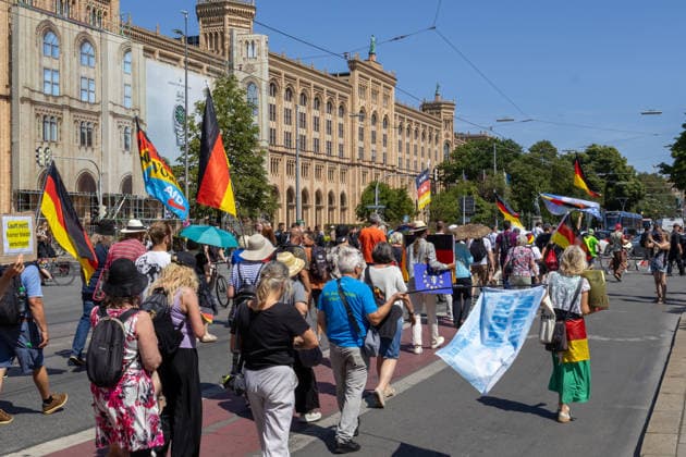 Munich, Bavaria, Germany - July 25, 2026: Protesters demonstrate in downtown Munich against Chancellor Friedrich Merz (CDU) and the federal government s policies. The rally is directed, among other things, against the government s economic and social policies. Protesters carrying German flags and flags of the AfD (Alternative for Germany) party *** Teilnehmer demonstrieren in der Münchner Innenstadt gegen Bundeskanzler Friedrich Merz (CDU) und die Politik der Bundesregierung. Die Kundgebung richtet sich unter anderem gegen die Regierungs- und Sozialpolitik. Demoteilnehmer mit Deutschland Flaggen bzw. Fahnen und Fahnen der Partei AfD (Alternative für Deutschland)