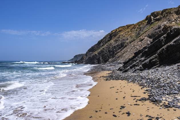 Creative Highlights World Schaumkronen brechen an einem goldenen Sandstrand, mit steinigen Klippen im Hintergrund und klarem Himmel, Rogil, Faro, Portugal Foam crowns break on a golden sandy beach, with rocky cliffs in the background and clear sky, Rogil, Faro, Portugal Copyright: imageBROKER AlexxStalder ibxaxr18460702.jpg