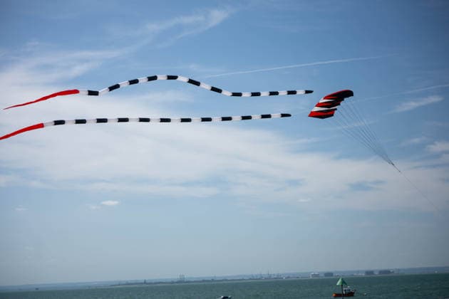 July 25, 2026, Essex, United Kingdom: A red parafoil kite trails long black-and-white striped tails across the sky above the sea during the Kite Festival at Southend-On-Sea. The Kite Festival Southend s Alternative Airshow, organised by Project Southchurch, was held on the Eastern Esplanade at Thorpe Bay seafront, Southend-On-Sea, Essex. Essex United Kingdom - ZUMAs197 20260725_aaa_s197_430 Copyright: xIanxDavidsonx