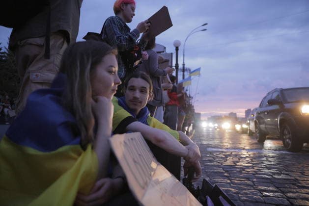 Protest Against Ukrainian President Zelenskiy s Decision To Replace Fedorov As Defence Minister, In Kharkiv Ukrainians gather along a wet street holding Ukrainian flags and signs to protest President Zelensky s decision to replace Defence Minister Fedorov, in Kharkiv, Kharkiv Oblast, Ukraine, on July 25, 2026. The evening demonstration drew residents who expressed concern over the ministerial change during the ongoing conflict. Vehicles with headlights illuminated line the street as the crowd gathers in the twilight hours. Kharkiv Kharkiv Oblast Ukraine  Copyright: xYevhenxTitovx originalFilename: titov-ukrainia260725_npxX8.jpg