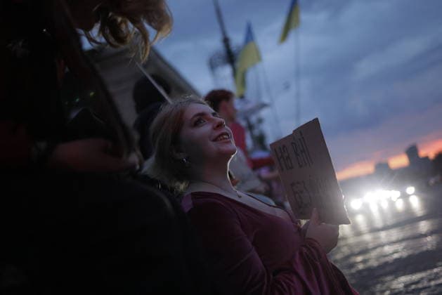 Ukrainians Protest - Kharkiv A protester holding a sign looks upward during a demonstration against Ukrainian President Volodymyr Zelenskiy s decision to replace Defence Minister Fedorov, in Kharkiv, Ukraine, on July 25, 2026. The evening rally drew crowds expressing opposition to the cabinet reshuffle, with ukrainian flags visible among the gathering as daylight faded over the city. Photo by Yevhen Titov ABACAPRESS.COM Kharkiv Kharkiv Oblast Ukraine  Copyright: xTitovxYevhen ABACAx