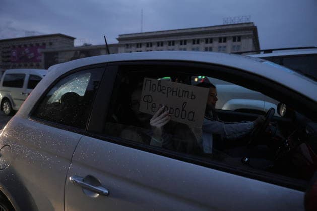 Ukrainians Protest - Kharkiv A protester holds a sign reading Trust Fedorov in Cyrillic script through a car window during a demonstration against President Zelenskiy s decision to replace Defence Minister Fedorov in Kharkiv, Ukraine, on July 25, 2026. The vehicle is parked in an urban area with Soviet-era administrative buildings visible in the background. Multiple vehicles participate in the car-based protest action. Photo by Yevhen Titov ABACAPRESS.COM Kharkiv Kharkiv Oblast Ukraine  Copyright: xTitovxYevhen ABACAx