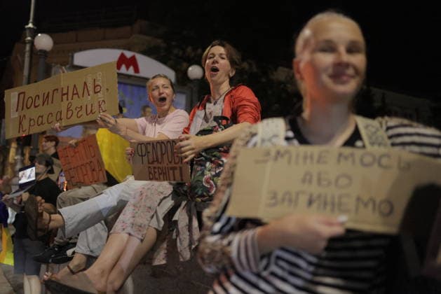 Ukrainians Protest - Kharkiv Protesters hold signs and shout slogans during a demonstration against Ukrainian President Volodymyr Zelenskiy s decision to replace Fedorov as Defence Minister in central Kharkiv, Ukraine, on July 25, 2026. The nighttime gathering drew residents expressing opposition to the personnel change, with participants holding placards written in Cyrillic script and a Ukrainian flag visible among the crowd. Photo by Yevhen Titov ABACAPRESS.COM Kharkiv Kharkiv Oblast Ukraine  Copyright: xTitovxYevhen ABACAx