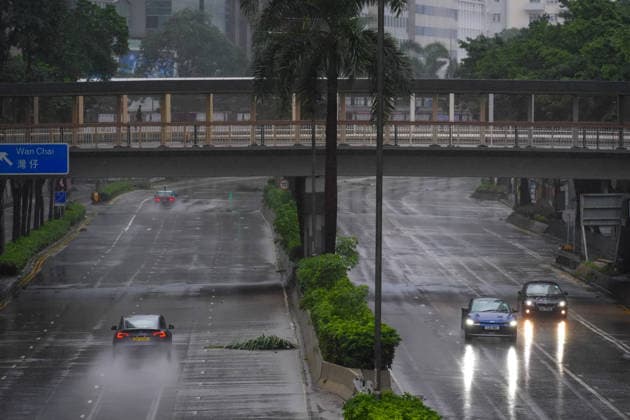 (260726) -- HONG KONG, July 26, 2026 -- A car drives past a broken branch on a road in Hong Kong, south China, July 26, 2026. The Hong Kong Observatory downgraded the typhoon signal to the Strong Wind Signal No. 3 at 12:40 p.m. local time on Sunday as Typhoon Noul moves away. With Noul moving into inland Guangdong and weakening, local winds are decreasing gradually, according to the observatory. ) CHINA-HONG KONG-TYPHOON SIGNAL-DOWNGRADE (CN) ZhuxWei 