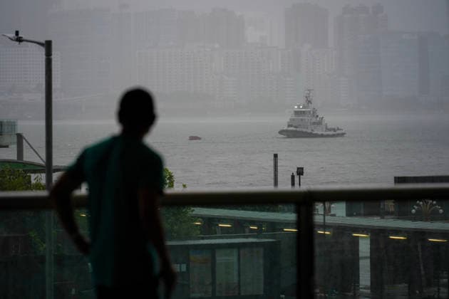 (260726) -- HONG KONG, July 26, 2026 -- A passerby looks towards the Victoria Harbour in Hong Kong, south China, July 26, 2026. The Hong Kong Observatory downgraded the typhoon signal to the Strong Wind Signal No. 3 at 12:40 p.m. local time on Sunday as Typhoon Noul moves away. With Noul moving into inland Guangdong and weakening, local winds are decreasing gradually, according to the observatory. ) CHINA-HONG KONG-TYPHOON SIGNAL-DOWNGRADE (CN) ZhuxWei 
