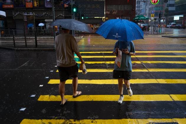 (260726) -- HONG KONG, July 26, 2026 -- People walk amid rain in Hong Kong, south China, July 26, 2026. The Hong Kong Observatory downgraded the typhoon signal to the Strong Wind Signal No. 3 at 12:40 p.m. local time on Sunday as Typhoon Noul moves away. With Noul moving into inland Guangdong and weakening, local winds are decreasing gradually, according to the observatory. ) CHINA-HONG KONG-TYPHOON SIGNAL-DOWNGRADE (CN) ZhuxWei 