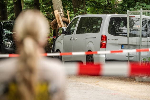 Tatort CSD-Anschlag am Ahornsteig im Tiergarten, Citroen Transporter krachte hier gestern Abend vor einen Baum, eine Frau schaut betroffen auf die Szene, Berlin, 26. Juli 2026 Deutschland, Berlin, 26. Juli 2026, Tatort CSD-Anschlag am Ahornsteig im Tiergarten, Citroen Transporter krachte hier gestern Abend vor einen Baum, Polizei untersucht Transporter und Anschlagsort, eine Absperrung riegelt den Bereich ab, eine Frau schaut betroffen auf die Szene, Sonntagmorgen um 10 Uhr, 12 Stunden nach dem Terroranschlag, bei dem ein Mensch starb und weitere teils schwer verletzt wurden, *** Crime Scene: CSD Attack on Ahornsteig in Tiergarten, A Citroën van crashed into a tree here last night; a woman looks on in shock at the scene, Berlin, July 26, 2