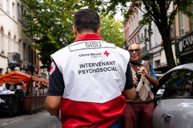 A SISU psychosocial worker pictured near a residential building at the Haachtsesteenweg chaussee de Haecht in Schaarbeek Schaerbeek, Brussels, where last night a fire broke out, Sunday 26 July 2026. Two people died in the fire. Eight others were injured. Two of them are in serious condition. The cause of the fire is still under investigation. MARIUS BURGELMAN  MariusxBurgelman 182073350