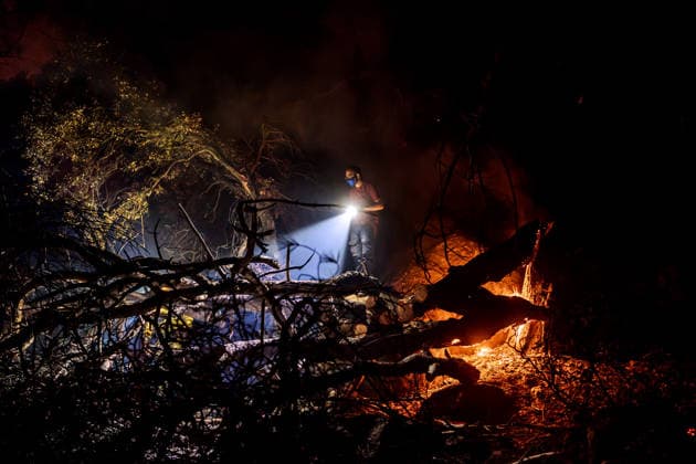 Evacuation underway as wildfires threaten towns in Spain LA ADRADA, AVILA, SPAIN – JULY 26: A resident uses a flashlight near burning trees during overnight wildfire suppression operations in La Adrada, in Spain s Avila province, on July 26, 2026. Residents and firefighters worked through the night as the fast-moving wildfire threatened nearby homes and forested areas. Diego Radames Anadolu Avila Spain. Editorial use only. Please get in touch for any other usage.  Copyright: x2026xAnadoluxDiegoxRadamesx