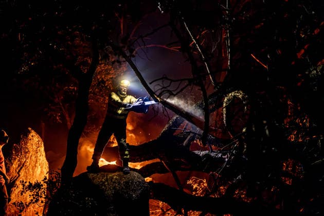 Evacuation underway as wildfires threaten towns in Spain LA ADRADA, AVILA, SPAIN – JULY 26: A firefighter uses a chainsaw to cut through burning trees during overnight wildfire suppression operations in La Adrada, in Spain s Avila province, on July 26, 2026. Fire crews worked throughout the night to contain the fast-moving blaze and prevent it from spreading toward nearby residential areas. Diego Radames Anadolu Avila Spain. Editorial use only. Please get in touch for any other usage.  Copyright: x2026xAnadoluxDiegoxRadamesx