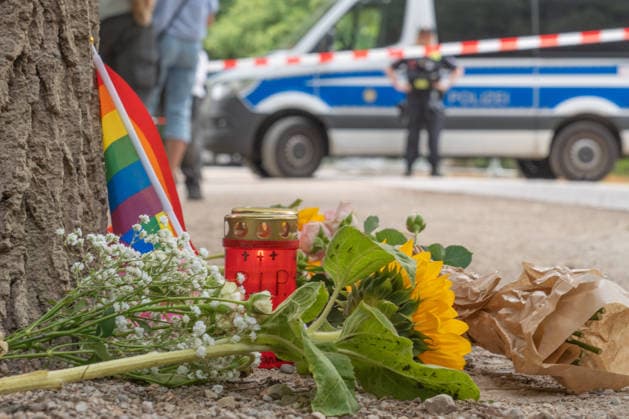 Tatort CSD-Anschlag am Ahornsteig im Tiergarten, Passanten haben zum Gedenken eine Regenbogenfahne, eine Kerze und Sonnenblumen niedergelegt, Trauer um die Opfer, Berlin, 26. Juli 2026 Deutschland, Berlin, 26. Juli 2026, Tatort CSD-Anschlag am Ahornsteig im Tiergarten, Passanten haben 80 Meter vom Tatort eine Regenbogenfahne, ein Grablicht und Sonnenblumen niedergelegt, einen Erinnerungsort geschaffen, ein Polizeifahrzeug riegelt den Bereich ab, dahinter steht noch immer der Citroen Transporter, der hier gestern Abend vor einen Baum krachte, Polizei untersucht Transporter und Anschlagsort, Szene am Sonntagmorgen um 11:45 Uhr, 14 Stunden nach dem Terroranschlag, bei dem ein Mensch starb und weitere teils schwer verletzt wurden, *** Crime Sce