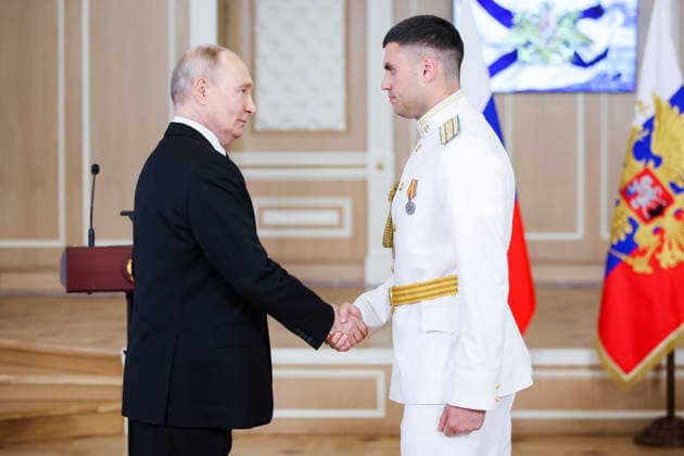 RUSSIA, ST PETERSBURG - JULY 26, 2026: Russia s President Vladimir Putin (L) awards Capt. Andrei Pustovoi Russia s Order of Courage during a ceremony to present state awards at the Admiralty Building on Russian Navy Day. Peter Kovalev TASS  95493606
