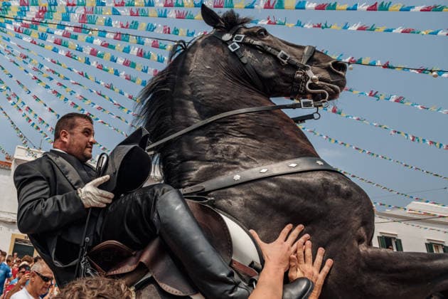 July 26, 2026, Fornells, Menorca Balearic Islands, Spain: A caixer, or horse rider, rears his horse amid a cheering crowd during the traditional Jaleo at the Sant Antoni Festival in Fornells. Fornells Spain  - ZUMAo105 20260726_fap_o105_008 Copyright: xMatthiasxOesterlex