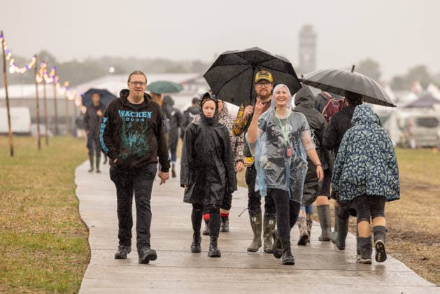 Anreise Wacken Open Air 2026 trotz Regenschauern gut organisiert, Veranstalterkonzept geht auf. Trotz des am Sonntag pünktlich einsetzenden Regens lassen sich die früh anreisenden Fans nicht abhalten und machen das Beste aus der Situation. Feste Wege und ein besseres Konzept zeigen bereits Wirkung. Wacken Wacken open Air Schleswig Holstein Deutschland _5DL7149 *** Travel to Wacken Open Air 2026 Well Organized Despite Rain Showers, Organizers’ plan pays off. Despite the rain starting right on schedule on Sunday, fans who arrived early weren’t deterred and made the best of the situation. Paved paths and an improved plan are already showing results. Wacken, Wacken Open Air, Schleswig-Holstein, Germany, 5DL7149