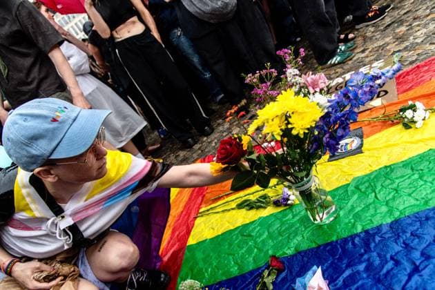 July 26, 2026, Berlin, Germany: BERLIN, GERMANY Ã¢â‚¬ JULY 26, 2026: People attend a vigil at the Brandenburg Gate in Berlin, Germany, following the deadly attack near the city s Christopher Street Day Pride celebrations a day earlier. Mourners laid flowers, candles, signs and LGBTQ+ pride flags in memory of the victims after a vehicle drove into a crowd, killing one person and injuring dozens. German authorities continued searching for the main suspect, identified as Abdul Ballout, whom police said had ties to Islamist extremist circles. Berlin Germany - ZUMAq101 20260726_zna_q101_116 Copyright: xAndro SxTrujillox
