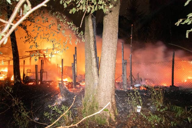 260727BrandGartenanlage News ID: EN 2026-07-27 Großbrand im unwegsamen Gelände: Feuerwehren rückten zu Brand von Gartenhütten aus Feuer drohte auf Wald überzugreifen Oelsnitz. Einsatzkräfte von Feuerwehr, Polizei und Rettungsdienst sind in der Nacht zum Montag zu einem Brandereignis in die Brückenstraße ausgerückt. Gegen 0:50 Uhr brach aus noch ungeklärter Ursache ein Brand in einer Gartenanlage auf der Brückenstraße aus. Bereits auf der Anfahrt der Feuerwehr war der Feuerschein sichtbar. Am Einsatzort angekommen bestätigte sich ein Brand mehrerer Gartenhütten in voller Ausdehnung. Zudem drohte der Brand auf einen angrenzenden Wald überzugreifen. Ein Löschangriff der Feuerwehr gestaltete sich zunächst schwierig, da der