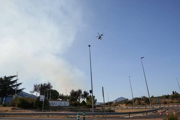 Firefighting helicopters battle reignited San Martin de Valdeiglesias wildfire near Navas del Rey NAVAS DEL REY (MADRID), SPAIN JULY 26, 2026: Firefighting helicopters carry out water-dropping operations as a large column of smoke rises from the reignited San Martin de Valdeiglesias wildfire, visible from several locations around Navas del Rey, near Madrid, on July 26. The series documents the aerial firefighting response, emergency vehicles and road closures implemented as crews continue efforts to contain the fire. Navas del Rey Spain Copyright: x xEugenioxRodriguezxRigox xJNAxPressx