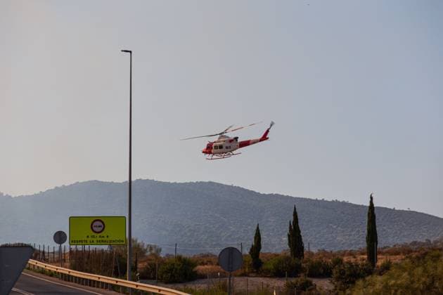 Firefighting helicopters battle reignited San Martin de Valdeiglesias wildfire near Navas del Rey NAVAS DEL REY (MADRID), SPAIN JULY 26, 2026: Firefighting helicopters carry out water-dropping operations as a large column of smoke rises from the reignited San Martin de Valdeiglesias wildfire, visible from several locations around Navas del Rey, near Madrid, on July 26. The series documents the aerial firefighting response, emergency vehicles and road closures implemented as crews continue efforts to contain the fire. Navas del Rey Spain Copyright: x xEugenioxRodriguezxRigox xJNAxPressx