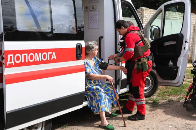 A paramedic in a ballistic vest measures a woman’s blood pressure after a direct hit from a Russian S8000 Banderol cruise missile on a residential area in the Slobidskyi district, Kharkiv, Ukraine, July 26, 2026. A 40-year-old woman was killed in the attack, and 12 people were injured. In total, at least 22 private houses and power lines were damaged in the district. (Photo by Viacheslav Madiievskyi Ukrinform) Russians strike residential area in Kharkiv with Banderol missile  Copyright: xViacheslavxMadiievskyix