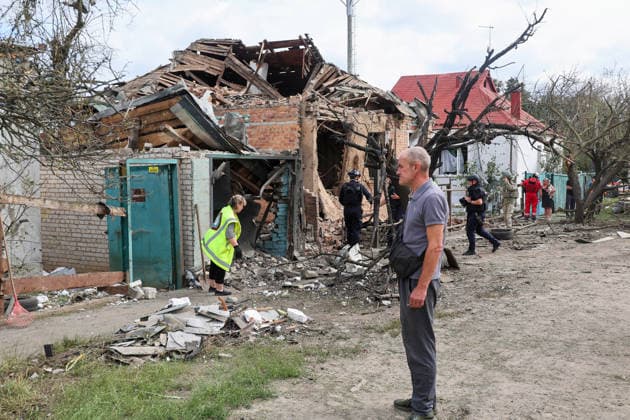 A municipal worker and law enforcers respond to a direct hit from a Russian S8000 Banderol cruise missile on a residential area in the Slobidskyi district, Kharkiv, Ukraine, July 26, 2026. A 40-year-old woman was killed in the attack, and 12 people were injured. In total, at least 22 private houses and power lines were damaged in the district. (Photo by Viacheslav Madiievskyi Ukrinform) Russians strike residential area in Kharkiv with Banderol missile  Copyright: xViacheslavxMadiievskyix