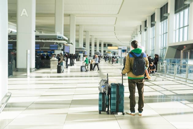 Father holding daughter and bags stands in a sunny airport terminal New York, New York, United States CR_UTHC260726-2074886-01 ,model released, Symbolfoto ,property released