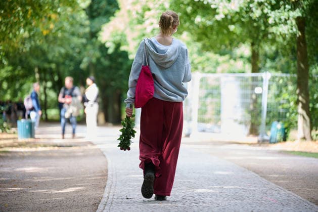Eine Frau mit Blumen geht im Berliner Tiergarten zu einem der Tatorte im Berliner Tiergarten, zwei Tage nach dem Anschlag auf die Feiern des 48. Berliner Christopher Street Day (CSD) mit einer Toten und 29 teils schwer Verletzten (Foto vom 27.07.2026). Der Christopher Street Day in Berlin war in der Nacht zum Sonntag von einem mutmasslich islamistisch motivierten Anschlag erschuettert worden, als ein Mann mit einem Kastenwagen in eine Menschenmenge im Berliner Tiergarten fuhr und mit einer Stichwaffe auf weitere Passanten losging. (Siehe epd-Bericht vom 27.07.2026) EDITORIAL USE ONLY *** A woman carrying flowers walks toward one of the crime scenes in Berlin’s Tiergarten, two days after the attack on the celebrations for the 48th Berlin Chr Copyright: epd-bild ChristianxDitsch D26D0727TrauerCSDAnschlag104800
