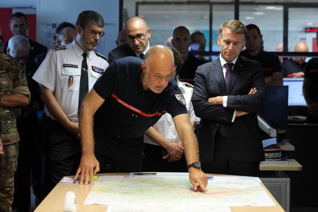 President Macron At Situation Briefing in the Crisis Room - Bordeaux France s President Emmanuel Macron (R) and France s Interior Minister Laurent Nunez (centre back) attend a situation briefing in the crisis room at the Departmental Fire and Rescue Operational Center (CODIS) in Bordeaux, following wildfires in the area, southwestern France, on July 27, 2026. France has been battered by three heatwaves since May as part of increasingly common extreme weather episodes linked to climate change, causing excess deaths, drying up rivers and fuelling wildfires. Scientists have long warned that climate change caused by human use of fossil fuels will make periods of drought more intense and longer-lasting, creating the ideal conditions for wildfire  Copyright: xPool ABACAx