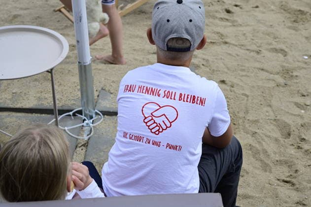 Ein Schüler trägt ein T-Shirt mit der Aufschrift: Frau Hennig soll bleiben. Sie gehört zu uns. Elternprotest - Grundschule Schöpstal droht Lehrerverlust. Große Unruhe zum Ferienbeginn an der Grundschule Schöpstal in Kunnersdorf: Einer langjährigen Klassenlehrerin droht im neuen Schuljahr die vollständige Abordnung an eine andere Schule. Da eine finale Entscheidung des Landesamtes für Schule und Bildung (LaSuB) noch aussteht, blicken viele Familien voller Ungewissheit auf die künftige Unterrichtsversorgung. Die Elternschaft wehrt sich nun massiv gegen den drohenden Unterrichtsausfall, den sie in der Vergangenheit bereits durch private Honorarkräfte im Sportunterricht abfedern musste. Mit einem offenen Brief an Ministerpräsident Copyright: xMatthiasxWehnertx