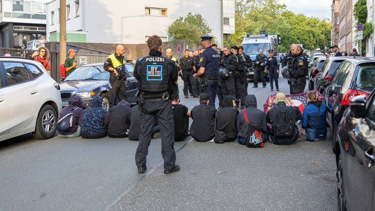 Montagsdemo Team Menschenrechte mit Gegendemonstration und Blockaden, Nürnberg, 27.07.2026 Mehrere Personen sitzen in einer Sitzblockade auf der oberen Turnstraße und werden von einem großen Polizeiaufgebot umstellt. Die Beamten, teils in Uniform mit Schutzausrüstung, sichern die Szene, im Hintergrund steht ein Wasserwerfer bereit. Nürnberg Bayern Deutschland *** Monday Demonstration: Human Rights Team Holds Counter-Demonstration and Blockades, Nuremberg, July 27, 2026 Several people are sitting in a sit-in blockade on Obere Turnstraße and are surrounded by a large police presence. The officers, some in uniform and wearing protective gear, are securing the scene; in the background, a water cannon stands at the ready. Nuremberg, Bava 20260727-286A2977-M4000