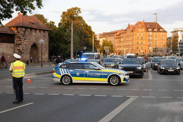 Montagsdemo Team Menschenrechte mit Gegendemonstration und Blockaden, Nürnberg, 27.07.2026 Ein Polizeifahrzeug sperrt mit einer Straßensperrung den Plärrer während der Demonstration ab, während ein Polizeibeamter den Verkehr regelt. Die langandauernde Sperrung führte zu Verärgerung bei wartenden Autofahrern und beeinträchtigte den umliegenden Straßenverkehr. Nürnberg Bayern Deutschland *** Monday Demonstration by the Human Rights Team, featuring a counter-demonstration and roadblocks, Nuremberg, July 27, 2026. A police vehicle blocks off the Plärrer with a roadblock during the demonstration, while a police officer directs traffic. The prolonged roadblock caused frustration among waiting drivers and disrupted traffic on surround 20260727-286A3072-M4000