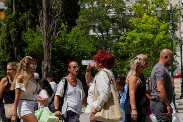 Athens Greece Heatwave A woman drinks water as people walk through Syntagma Square in Athens, Attica, Greece on July 27, 2026. Visitors and residents gather in the square as high summer temperatures persist in the Greek capital. Athens Attica Greece Copyright: xElvisxTakahashixMantellox