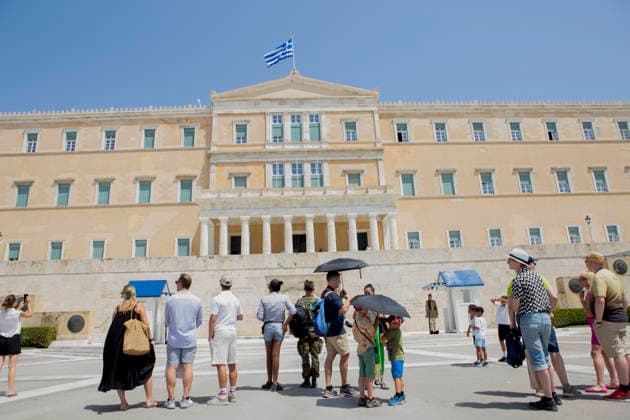 Athens Greece Heatwave People use umbrellas while watching the changing of the guard ceremony outside the Hellenic Parliament at the Tomb of the Unknown Soldier in Athens, Attica, Greece on July 27, 2026. Visitors gather to watch the ceremony as high summer temperatures persist in the Greek capital. Athens Attica Greece Copyright: xElvisxTakahashixMantellox
