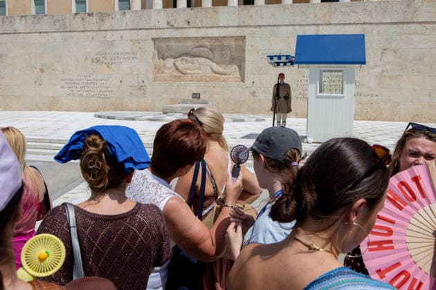 Athens Greece Heatwave People use handheld fans and cover their heads with shirts while watching the changing of the guard ceremony outside the Hellenic Parliament at the Tomb of the Unknown Soldier in Athens, Attica, Greece on July 27, 2026. Visitors gather to watch the ceremony as high summer temperatures persist in Athens. Athens Attica Greece Copyright: xElvisxTakahashixMantellox