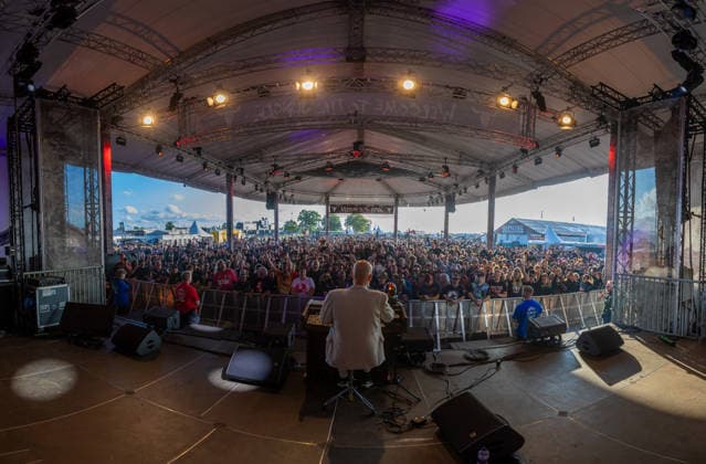 Wacken 2926 viele Fans bereits vor dem offiziellen Beginn eingetroffen. Mambo Kurt lässt mit seiner Hamondorgel den Platz bereits eskalieren! Bei gutem Wetter eröffnen die ersten Stände bereits vor der offiziellen Eröffnung. Damit ist der Bereich um die Zeltplätze bei gutem Wetter am Montag gut gefüllt und zehntausende Metalheads geniessen das Festival vor dem Festival. Wacken Wacken open Air Schleswig Holstein Deutschland IVDJ6381-Pano *** Wacken 2926: Many fans have already arrived before the official start. Mambo Kurt is already getting the crowd going with his Hammond organ. Thanks to the good weather, the first food stands are already open before the official opening. As a result, the area around the campsites is well-populated