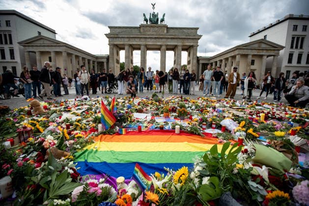 Menschen gedenken mit Blumen, Kerzen, Regenbogenflaggen und Solidaritätsnachrichten an den Opfer der Anschlag vom 25. Juli an den CSD vor dem Brandenburger Tor in Berlin am 27. Juli 2026. Der vermeintliche Attänteter Abdul B. soll mit einem LKW in dem Tiergarten gefahren und eine Frau getötet und weiter 29 Menschen verletzt haben. Gestern laut Polizei und LKA soll er während eine Operation in einer Gartenkolonie in Spandau aufgespürt und erschossen worden sein. Berliner gedenken an den Opfern der Attacke an den CSD *** People pay their respects with flowers, candles, rainbow flags, and messages of solidarity for the victims of the July 25 attack at the CSD in front of the Brandenburg Gate in Berlin on July 27, 2026. The alleged attacker, Ab