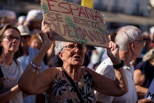 Demonstration over the fires in Madrid - 27 Jul 2026 A protester holds a placard that reads in Spanish, Spain is burningî during a demonstration at the Puerta del Sol in central Madrid. People from the Tietar Valley, Avila, in the Castile and Leon region, held a protest against the handling of the wildfires affecting dozens of municipalities in the area and the neglect of the land. Madrid Spain Copyright: xLuisxSotox xSOPAxImagesx LSOTOMPT07