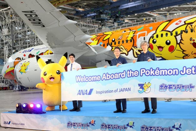 July 28, 2026, Tokyo, Japan - All Nippon Airways (ANA) executive vice president Keiji Omae (2nd R) and Pokemon company COO Takato Utsunomiya (R) pose for photo with Pokemon character Pikachu (L) as ANA displays the special designed aircraft with Pokemon characters Red Pokemon Jet to mark the 30th annivrersary of the partnership of ANA and Pokemon at the ANA hangar near the Haneda airport in Tokyo on Tuesday, July 28, 2026. ANA will start domestic flight services of Red Pokemon Jet from July 29. (photo by Yoshio Tsunoda AFLO)  aflo_339375470