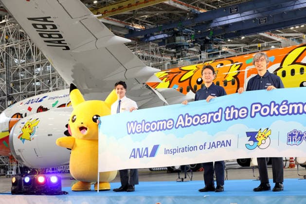 July 28, 2026, Tokyo, Japan - All Nippon Airways (ANA) executive vice president Keiji Omae (2nd R) and Pokemon company COO Takato Utsunomiya (R) pose for photo with Pokemon character Pikachu (L) as ANA displays the special designed aircraft with Pokemon characters Red Pokemon Jet to mark the 30th annivrersary of the partnership of ANA and Pokemon at the ANA hangar near the Haneda airport in Tokyo on Tuesday, July 28, 2026. ANA will start domestic flight services of Red Pokemon Jet from July 29. (photo by Yoshio Tsunoda AFLO)  aflo_339375471