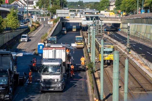 Sanierung der Autobahn A40 zwischen Mülheim-Winkhausen und Essen-Ost, auf 5,8 Kilometer wurde die Asphaltdecke erneuert, mit s.g. Flüsterasphalt, offenporiger Asphalt, in beide Fahrtrichtungen, insgesamt über 110.000 Quadratmeter, eine Woche Vollsperrung, mit starker Verkehrsbehinderungen im Ruhrgebiet, Essen, NRW, Deutschland Autobahnsanierung *** Renovation of the A40 highway between Mülheim Winkhausen and Essen Ost: The asphalt pavement was replaced over a 5.8-kilometer stretch with so-called whisper asphalt (open-pored asphalt) in both directions, totaling over 110,000 square meters; the highway was fully closed for one week, causing severe traffic disruptions in the Ruhr region, Essen, North Rhine-Westphalia, and Germany. Highway