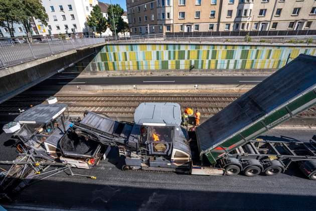 Sanierung der Autobahn A40 zwischen Mülheim-Winkhausen und Essen-Ost, auf 5,8 Kilometer wurde die Asphaltdecke erneuert, mit s.g. Flüsterasphalt, offenporiger Asphalt, in beide Fahrtrichtungen, insgesamt über 110.000 Quadratmeter, eine Woche Vollsperrung, mit starker Verkehrsbehinderungen im Ruhrgebiet, Essen, NRW, Deutschland Autobahnsanierung *** Renovation of the A40 highway between Mülheim Winkhausen and Essen Ost: The asphalt pavement was replaced over a 5.8-kilometer stretch with so-called whisper asphalt (open-pored asphalt) in both directions, totaling over 110,000 square meters; the highway was fully closed for one week, causing severe traffic disruptions in the Ruhr region, Essen, North Rhine-Westphalia, and Germany. Highway