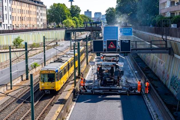 Sanierung der Autobahn A40 zwischen Mülheim-Winkhausen und Essen-Ost, auf 5,8 Kilometer wurde die Asphaltdecke erneuert, mit s.g. Flüsterasphalt, offenporiger Asphalt, in beide Fahrtrichtungen, insgesamt über 110.000 Quadratmeter, eine Woche Vollsperrung, mit starker Verkehrsbehinderungen im Ruhrgebiet, Essen, NRW, Deutschland Autobahnsanierung *** Renovation of the A40 highway between Mülheim Winkhausen and Essen Ost: The asphalt pavement was replaced over a 5.8-kilometer stretch with so-called whisper asphalt (open-pored asphalt) in both directions, totaling over 110,000 square meters; the highway was fully closed for one week, causing severe traffic disruptions in the Ruhr region, Essen, North Rhine-Westphalia, and Germany. Highway