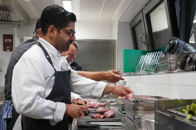 Hessens Wirtschaftsminister Kaweh Mansoori (SPD) und der Landrat des Kreis Groß-Gerau Thomas Will (SPD) bereiten in der Küche des AVM-Ausbildungsrestaurants Mangold in Bischofsheim ein Backhendl in Kürbiskern-Panade zu mit Küchenchef Florian Rothbauer - Bischofsheim 28.07.2026: Wirtschaftsminister Kaweh Mansoori besucht das Mangold *** Hesse’s Minister of Economic Affairs, Kaweh Mansoori (SPD), and Thomas Will (SPD), District Administrator of Groß Gerau, are preparing a fried chicken in a pumpkin seed breading in the kitchen of the AVM Mangold training restaurant in Bischofsheim with Head Chef Florian Rothbauer. Bischofsheim, July 28, 2026 Minister of Economic Affairs Kaweh Mansoori visits the Mangold