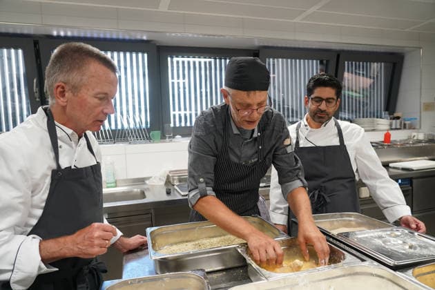 Hessens Wirtschaftsminister Kaweh Mansoori (SPD) und der Landrat des Kreis Groß-Gerau Thomas Will (SPD) bereiten in der Küche des AVM-Ausbildungsrestaurants Mangold in Bischofsheim ein Backhendl in Kürbiskern-Panade zu mit Küchenchef Florian Rothbauer - Bischofsheim 28.07.2026: Wirtschaftsminister Kaweh Mansoori besucht das Mangold *** Hesse’s Minister of Economic Affairs, Kaweh Mansoori (SPD), and Thomas Will (SPD), District Administrator of Groß Gerau, are preparing a fried chicken in a pumpkin seed breading in the kitchen of the AVM Mangold training restaurant in Bischofsheim with Head Chef Florian Rothbauer. Bischofsheim, July 28, 2026 Minister of Economic Affairs Kaweh Mansoori visits the Mangold