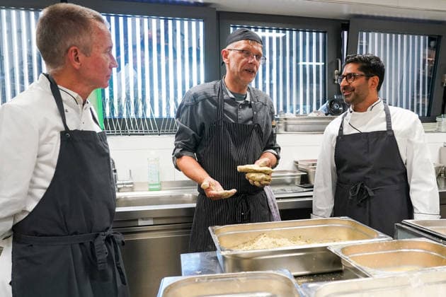 Hessens Wirtschaftsminister Kaweh Mansoori (SPD) und der Landrat des Kreis Groß-Gerau Thomas Will (SPD) bereiten in der Küche des AVM-Ausbildungsrestaurants Mangold in Bischofsheim ein Backhendl in Kürbiskern-Panade zu mit Küchenchef Florian Rothbauer - Bischofsheim 28.07.2026: Wirtschaftsminister Kaweh Mansoori besucht das Mangold *** Hesse’s Minister of Economic Affairs, Kaweh Mansoori (SPD), and Thomas Will (SPD), District Administrator of Groß Gerau, are preparing a fried chicken in a pumpkin seed breading in the kitchen of the AVM Mangold training restaurant in Bischofsheim with Head Chef Florian Rothbauer. Bischofsheim, July 28, 2026 Minister of Economic Affairs Kaweh Mansoori visits the Mangold