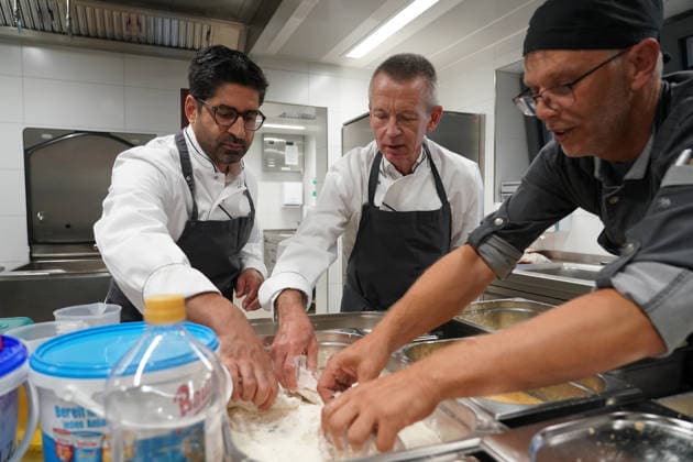 Hessens Wirtschaftsminister Kaweh Mansoori (SPD) und der Landrat des Kreis Groß-Gerau Thomas Will (SPD) bereiten in der Küche des AVM-Ausbildungsrestaurants Mangold in Bischofsheim ein Backhendl in Kürbiskern-Panade zu mit Küchenchef Florian Rothbauer - Bischofsheim 28.07.2026: Wirtschaftsminister Kaweh Mansoori besucht das Mangold *** Hesse’s Minister of Economic Affairs, Kaweh Mansoori (SPD), and Thomas Will (SPD), District Administrator of Groß Gerau, are preparing a fried chicken in a pumpkin seed breading in the kitchen of the AVM training restaurant Mangold in Bischofsheim with Head Chef Florian Rothbauer. Bischofsheim, July 28, 2026 2026 Minister of Economic Affairs Kaweh Mansoori visits the Mangold