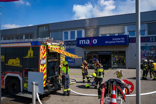 Brand in Lagerhalle Feuerwehren aus mehreren Kommunen im Einsatz Am 28.07.2026 kam es gegen 09:00 Uhr zu einem Brand in einer Lagerhalle in der Gutenbergstraße in Kriftel. Feuerwehr und Polizei sowie Feuerwehren aus dem Umkreis Hofheim und Bad Soden sind vor Ort im Einsatz, die Löscharbeiten dauern derzeit an. Zum Einsatz kommen ein mobiler Lüfter, der die Halle mit einem Wasser-Luft-Gemisch bebläst, sowie eine Drohne, die das Hallendach überfliegt. Aufgrund des Einsatzes sind die Gutenbergstraße sowie die Bachstraße gesperrt, im Umfeld kann es zu Geruchsbelästigungen kommen. Das DRK hat gegen 11:30 Uhr eine Versorgungsstation für die Einsatzkräfte aufgebaut, eine Gefahr für die Bevölkerung besteht nach aktuellem Stand nicht