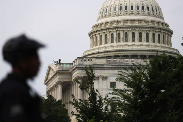 July 28, 2026, Washington, District Of Columbia, USA: Seen beyond a U.S. Capitol Police officer, snipers stand guard on a rooftop at the U.S. Capitol building ahead of a memorial service for U.S. Senator Lindsey Graham (R-SC) in Washington, D.C. on July 28, 2026. Washington USA - ZUMAd227 20260728_znp_d227_010 Copyright: xBryanxDozierx
